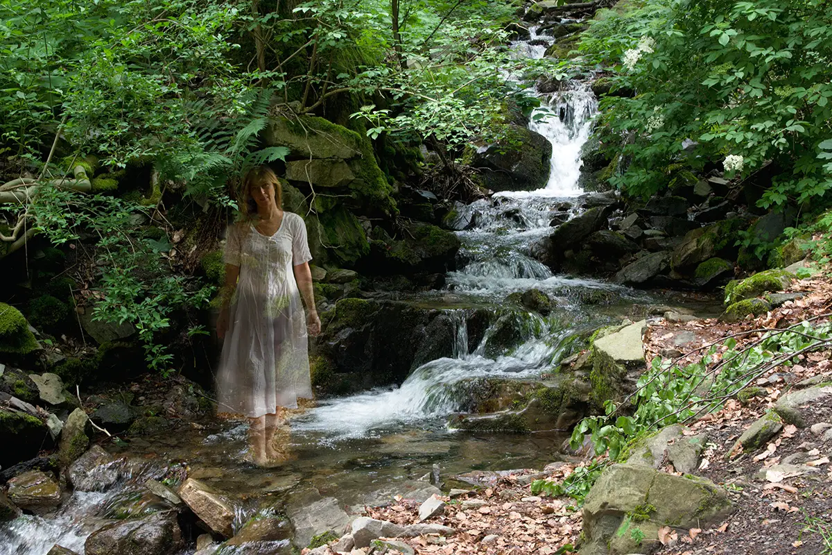 Příběhy čtenářů: Éterická postava víly v bílých šatech u lesního vodopádu v Krušných horách, doprovázející mystický příběh z údolí Chomutovky
