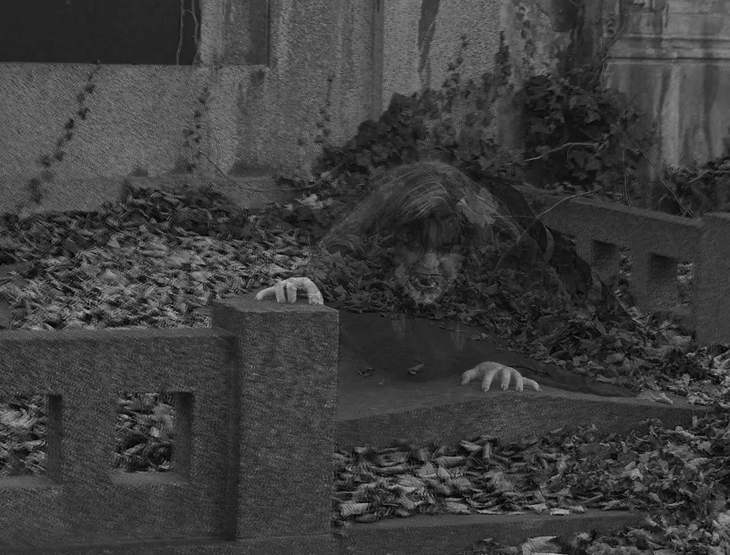 Umělecká černobílá fotografie Miroslava Neumaiera znázorňující nemrtvou ženu vystupující z hrobu během magické noci na Velký pátek.