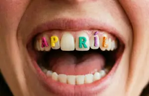 Detail rozesmátých úst s nápisem Apríl na zubech, kreativní fotografie Miroslava Neumaiera pro e-magazín Tvoje příběhy.