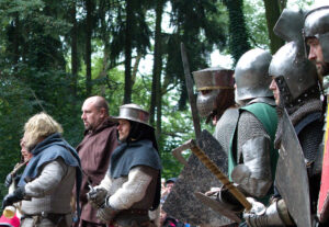Historická rekonstrukce bitvy u Ústí nad Labem (1426): Skupina husitských bojovníků v dobové zbroji (plechový klobouk, kroužková košile, prošívanice) se připravuje k boji